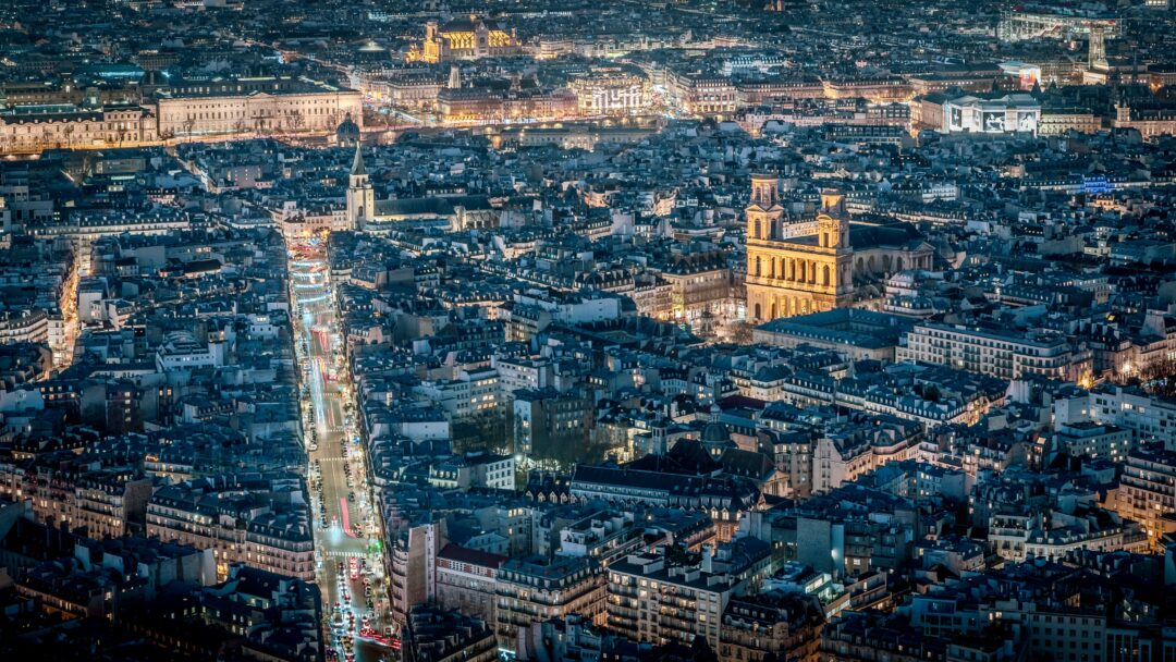 View of a bustling city skyline at night with numerous illuminated buildings, Paris, France