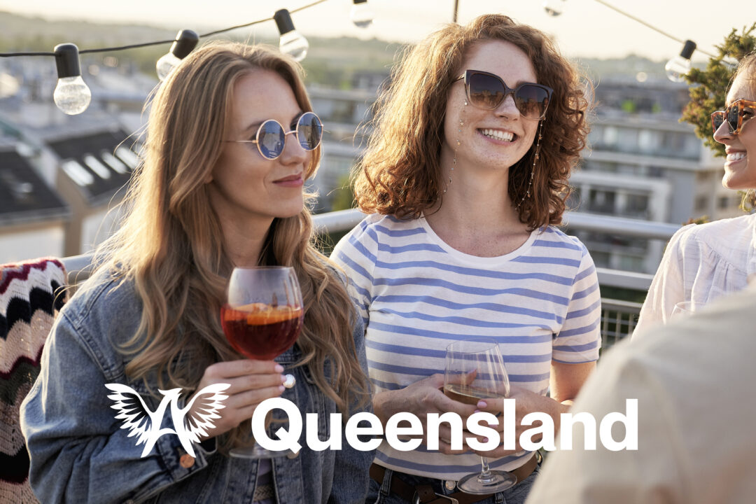 Three women toasting with white wine on patio