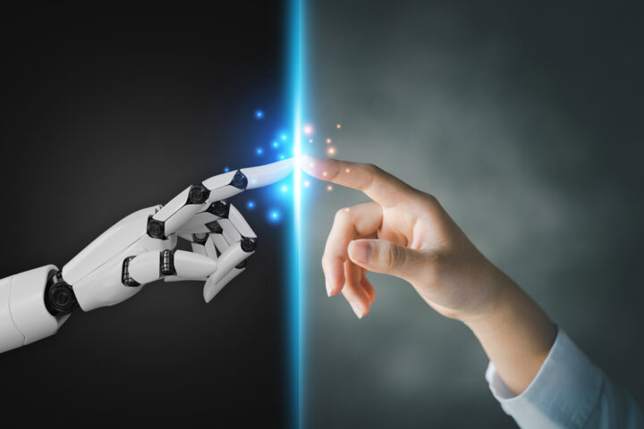 Robot and human hands pointing to each other, the idea of creati